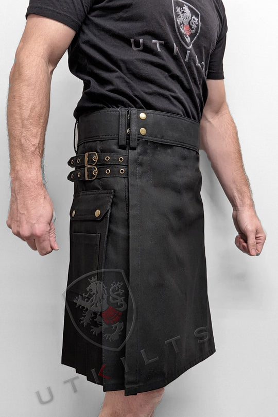 Black utility kilt adorned with gold hardware, exemplifying a modern and practical design for versatile wear.