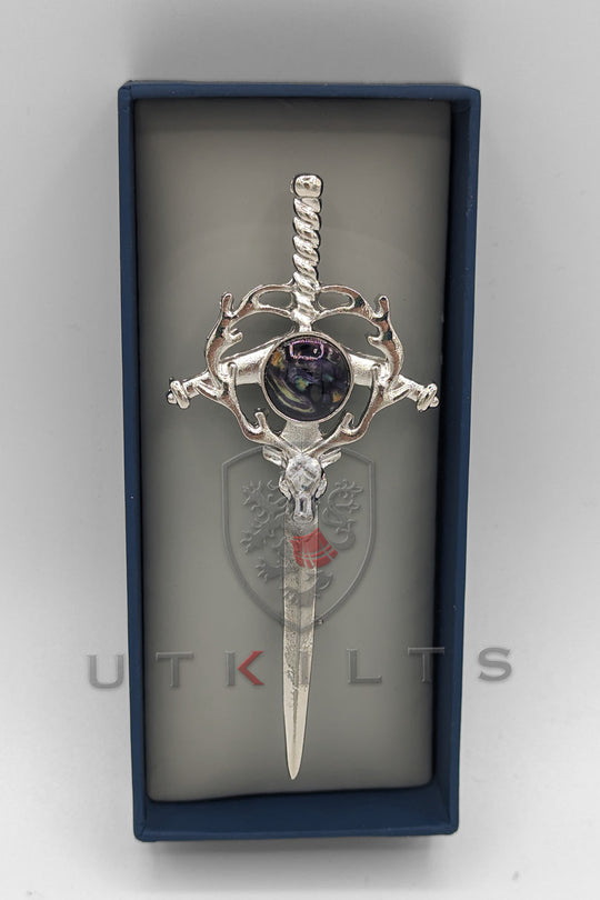 A beautifully crafted silver and blue cross adorned with a striking purple stone, representing devotion and elegance.
