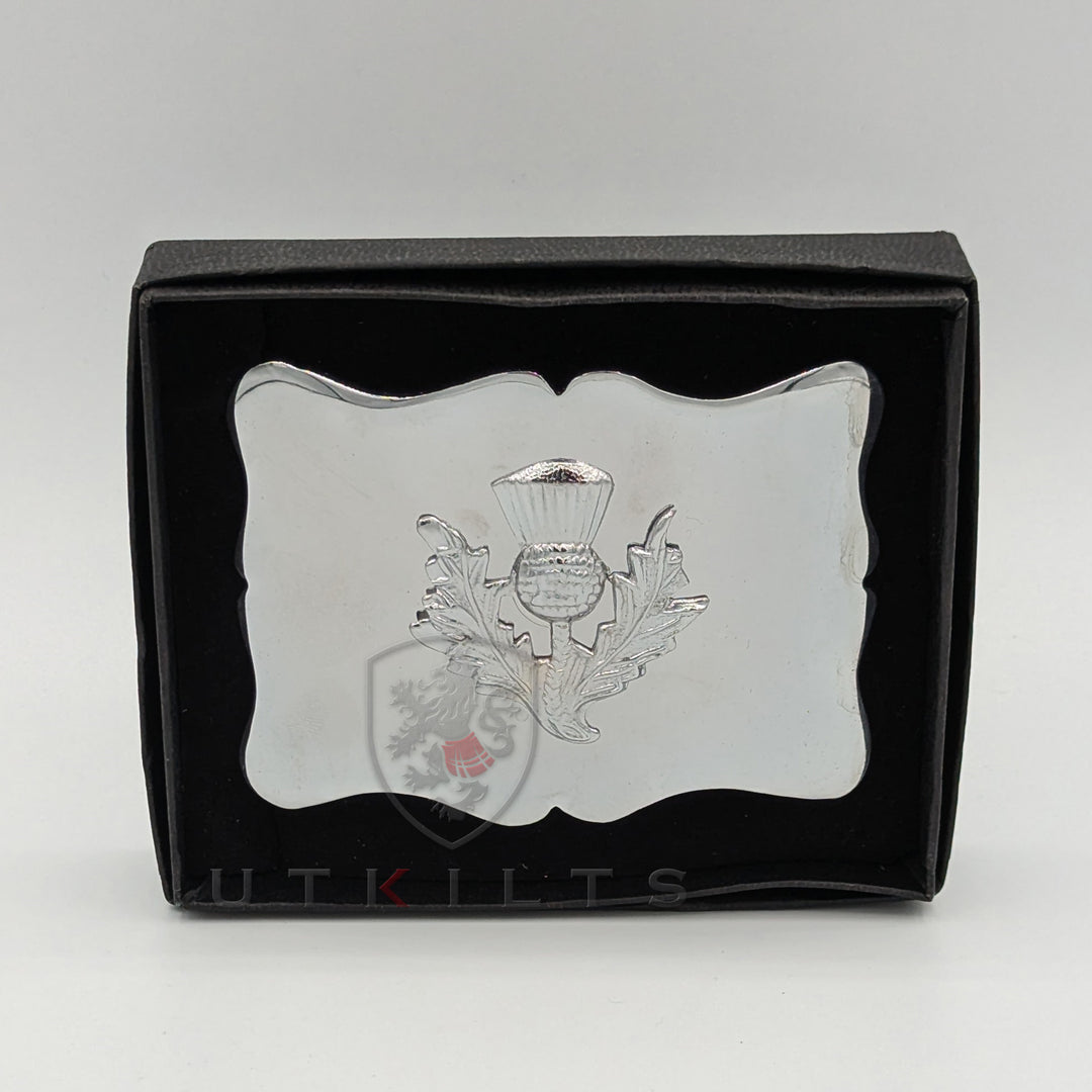 A silver plated belt buckle featuring an intricately designed Scottish thistle emblem.