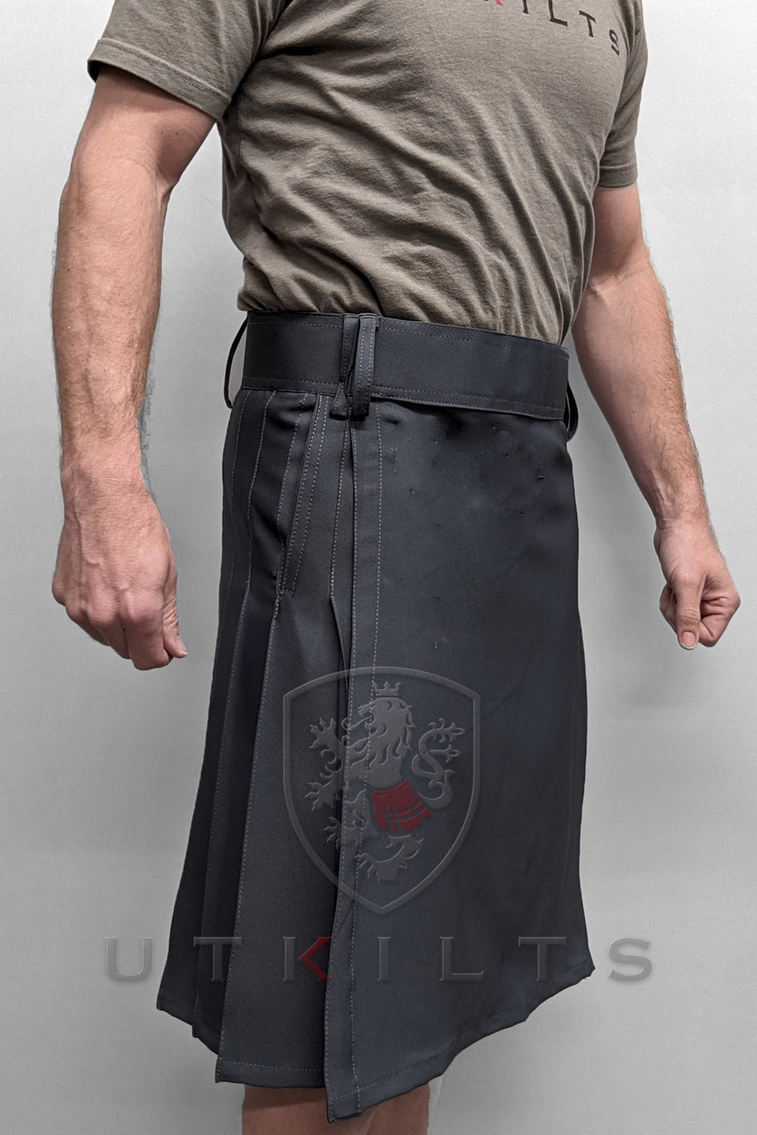 Front view of a man wearing a gray workout kilt with a belt, highlighting a unique fusion of athletic wear and cultural attire.