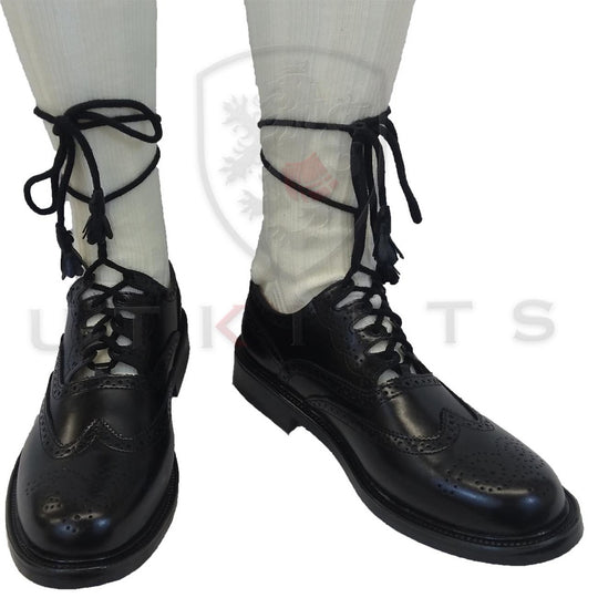 A pair of black lace-up shoes displayed on a neutral background, showcasing their sleek design and polished finish.