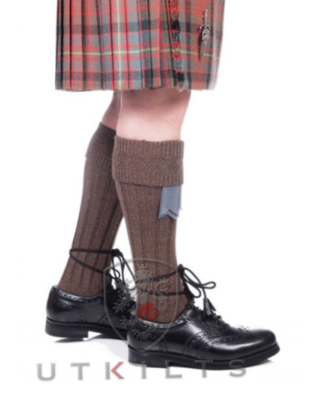 A man in a kilt paired with Premium Weathered Brown Kilt Hose and black shoes.