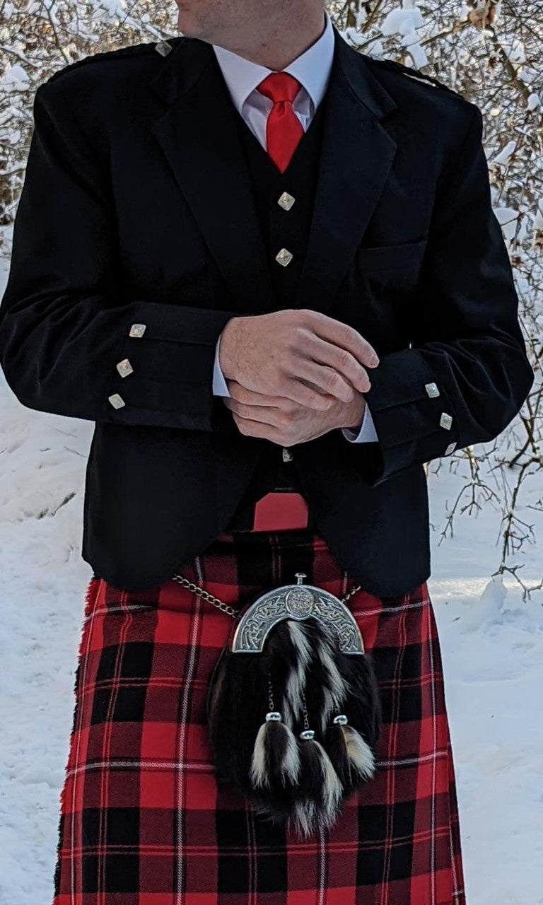 A man wearing a kilt poses in the snow, highlighting the Argyll Formal Kilt Jacket and Vest - 52R in a winter setting.