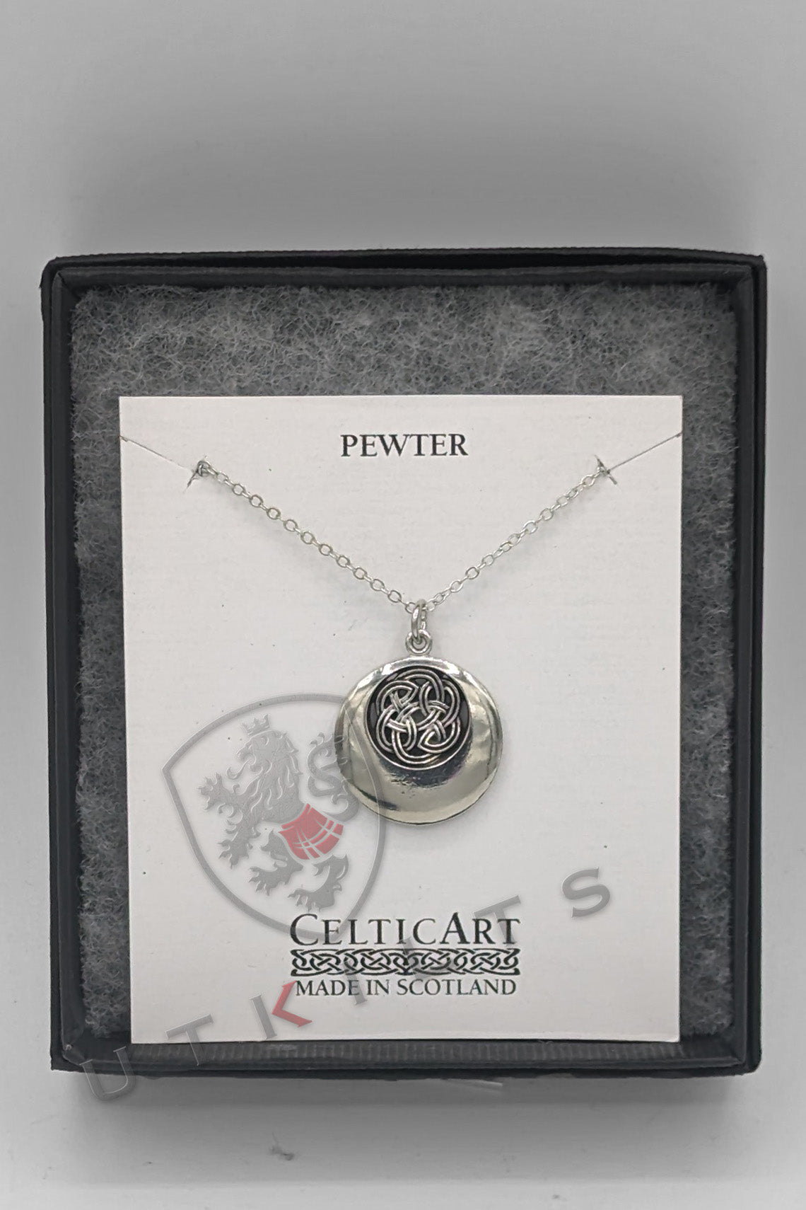 A silver pendant featuring an intricate black and white Celtic design, showcasing a rounded knot pattern.