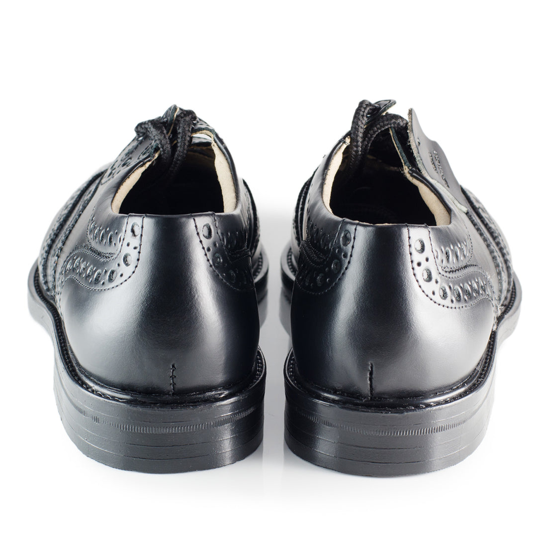 A pair of black leather shoes featuring an intricate brogue pattern, showcasing elegance and craftsmanship.