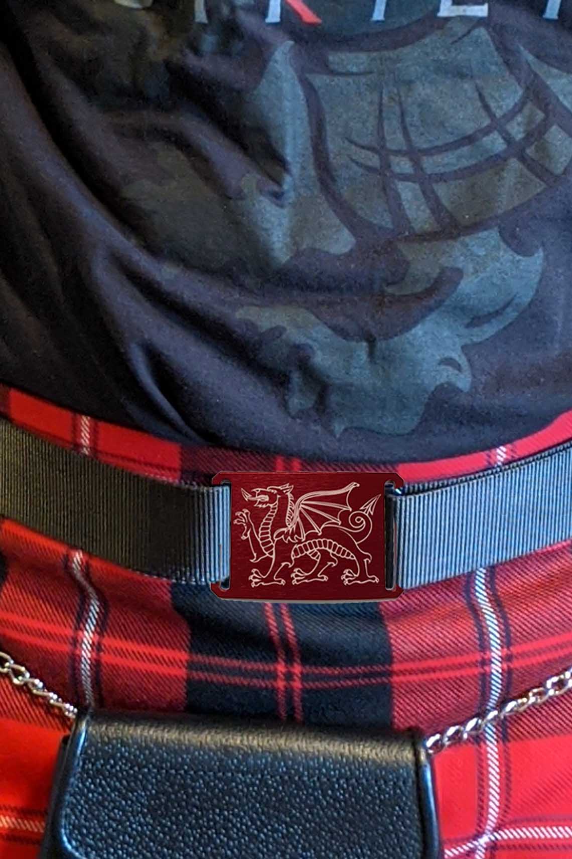 A man in a red tartan kilt, accessorized with a belt, showcasing UTK Exclusives fashion style.