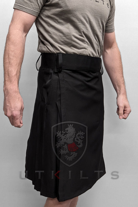 A man showcases a black workout kilt paired merging functionality with contemporary fashion.