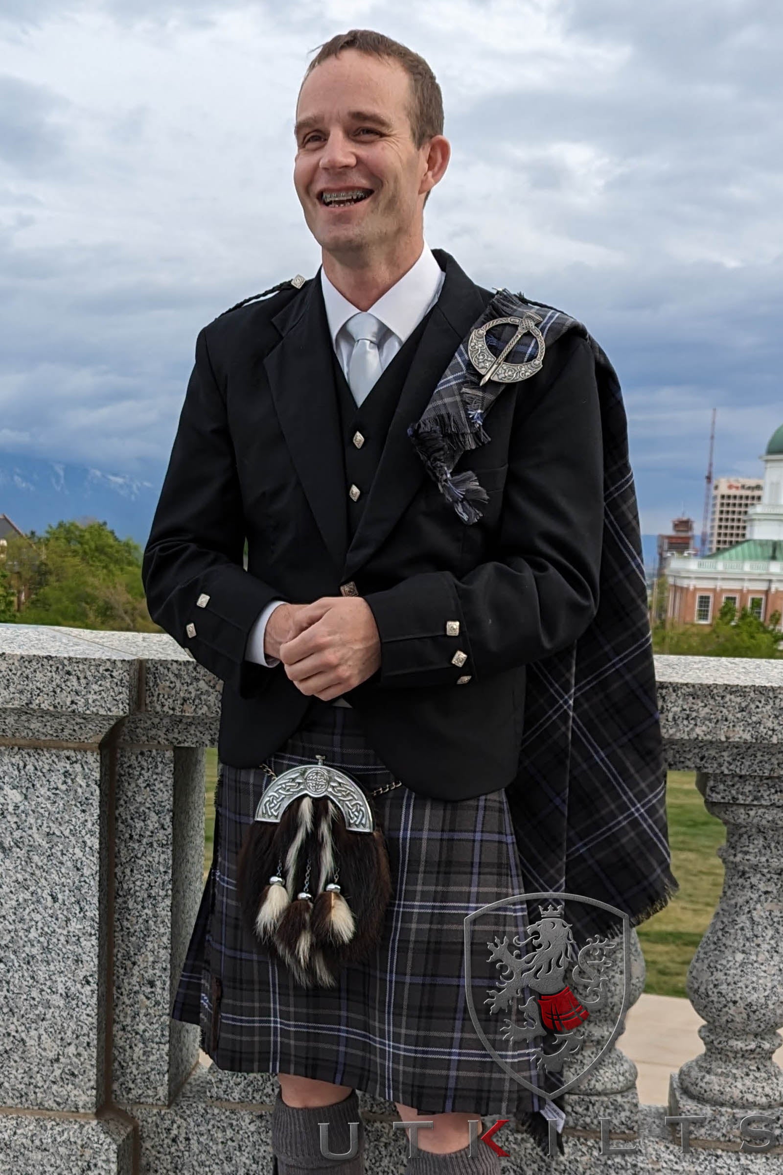 A man poses for a photo in a specially ordered 8-yard tartan kilt, highlighting the elegance of Scottish fashion.