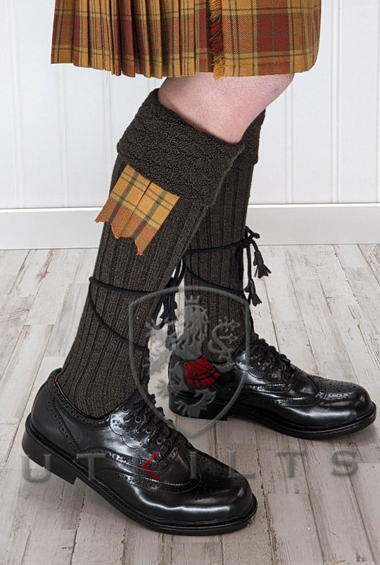 A man in a kilt paired with Premium Diamond Patterned Kilt Hose and black shoes.