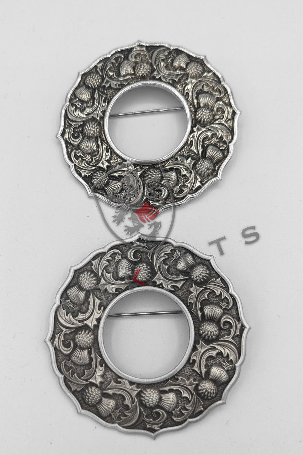  Two elegant silver-plated brooches featuring intricate floral designs, showcasing craftsmanship and beauty.