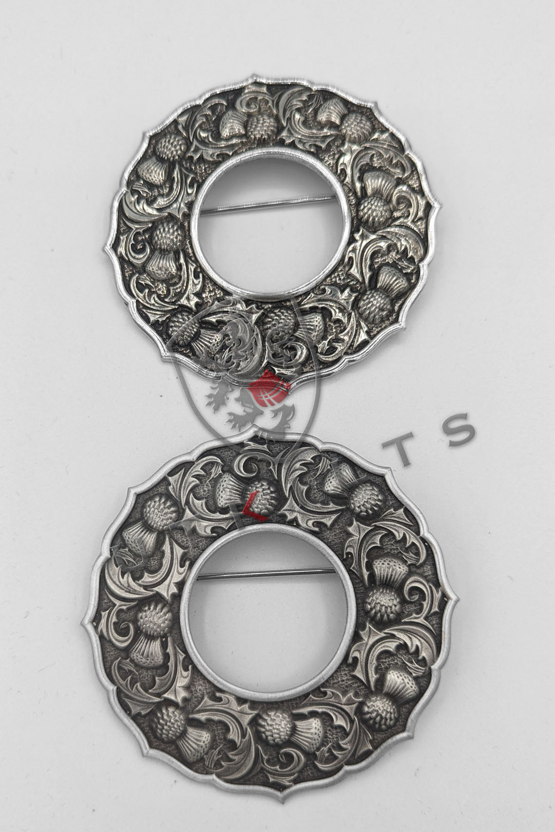  Two elegant silver-plated brooches featuring intricate floral designs, showcasing craftsmanship and beauty.