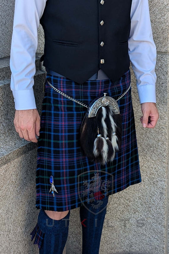 A man wearing a kilt stands atop a wall, representing Scottish tradition with Welsh kilts available from $225.