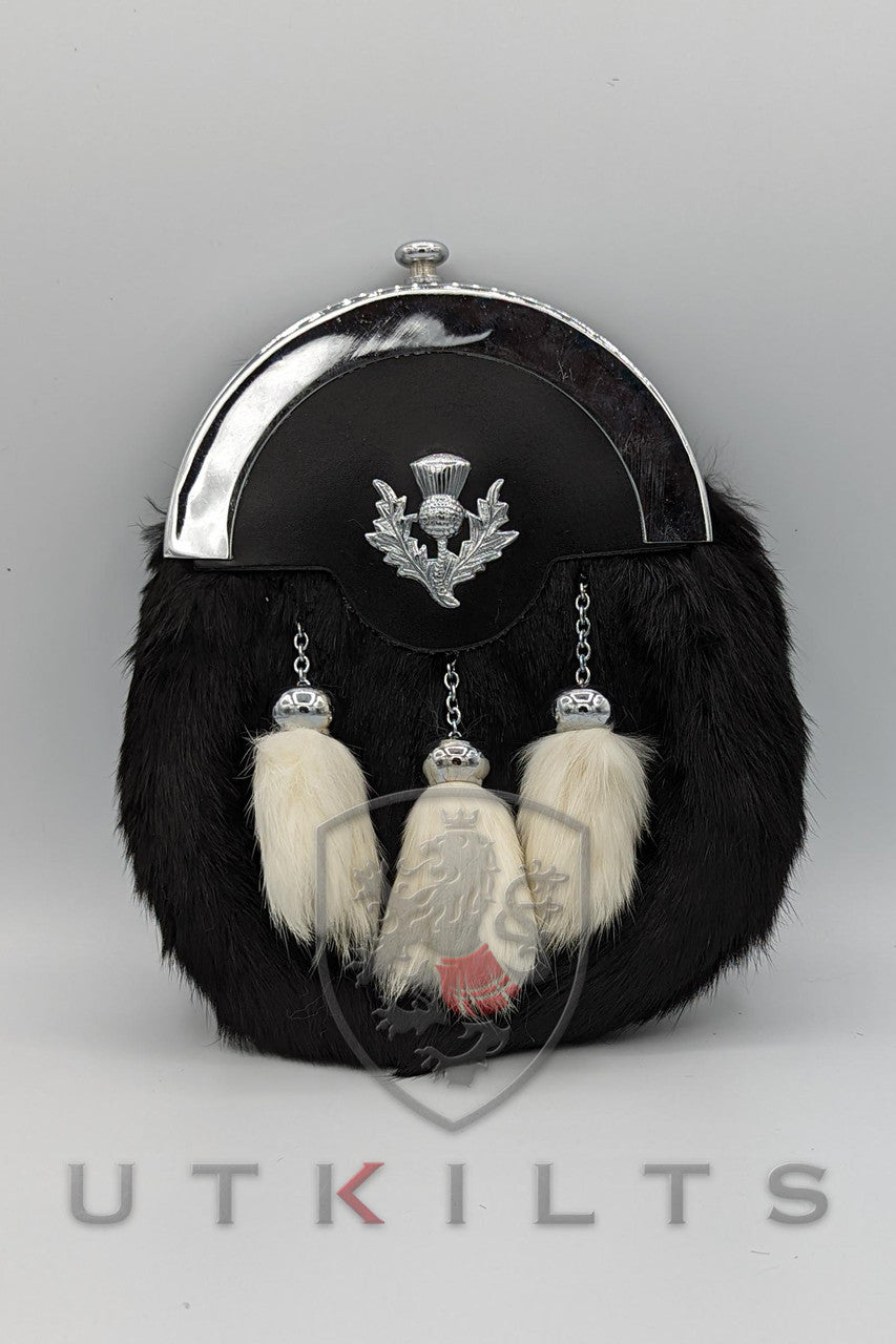 A formal black and white fur bag featuring two tassels and a thistle badge, designed for elegant attire.