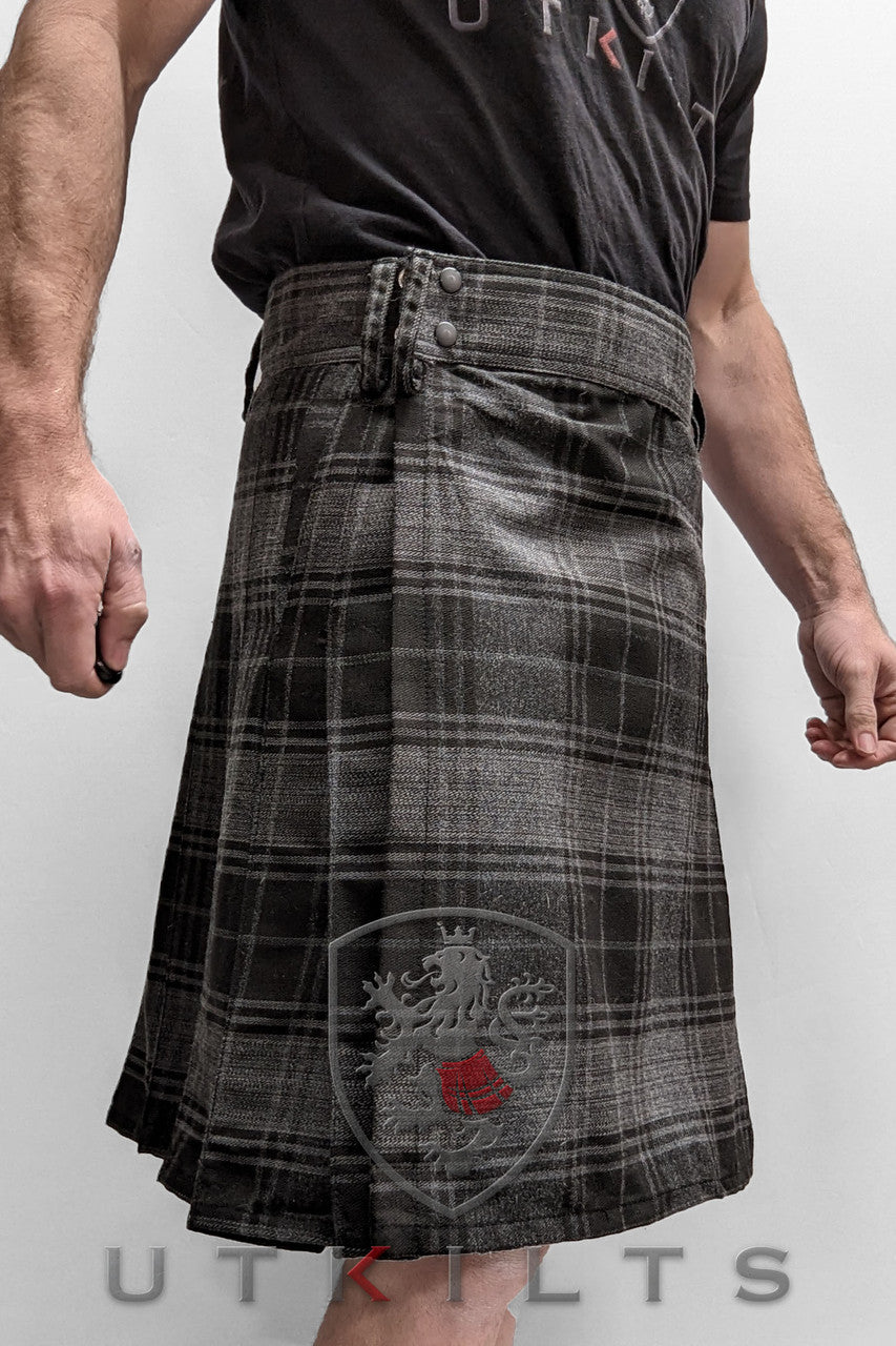 A man models a utility kilt in Highlander Gray tartan.